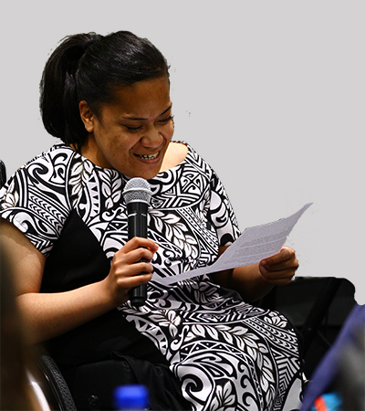 Woman in wheelchair with microphone reading a speech