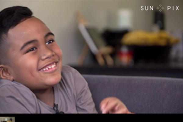 Young boy on home couch being interviewed