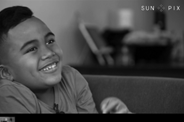 Young boy on home couch being interviewed